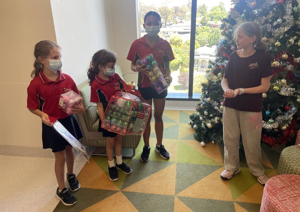 Epsom Primary School students Lucy Johnston, Victoria Payne and Eh Tha Yu Htoo present the gifts to patient Catherine McKenner. Picture by David Chapman 