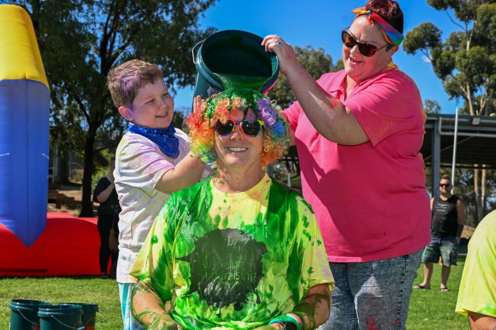 Student Harry Clark and Hollie Vosper tip the bucket of slime on Specimen Hill Primary School principal Jac Loutitt. Picture by Enzo Tomasiello
