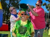 Student Harry Clark and Hollie Vosper tip the bucket of slime on Specimen Hill Primary School principal Jac Loutitt. Picture by Enzo Tomasiello