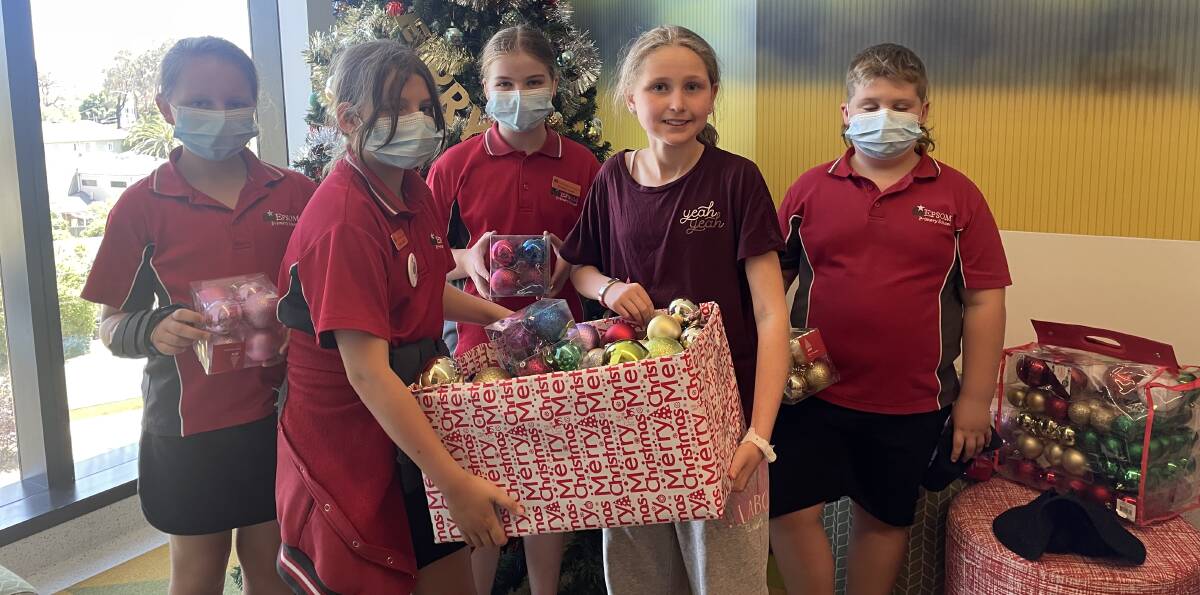 Epsom school students Ayla Bickerdike, Rylie Mooney, Amelia Dobson and Mason Carboon present their gifts to patient Catherine McKenner. Picture by David Chapman