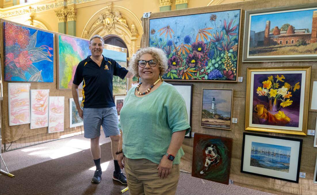 Art show co-ordinator Brian Figg and Bendigo Rotary Club president Daniela Ionescu among the works on show - and sale - at the Easter art show. Picture by Enzo Tomasiello
