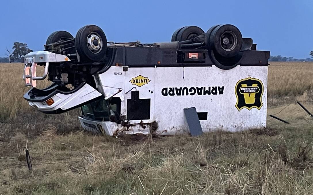 The Armaguard van ended up on its roof in a paddock. Picture by David Chapman
