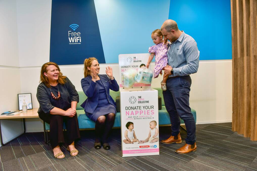 Lauren Read from The Nappy Collective, ANZ staffer Jordana Diss and branch manager Louis Meyer with his daughter Pia, aged 2 and a half are helping to collect nappies for vulnerable local families. Picture: BRENDAN MCCARTHY