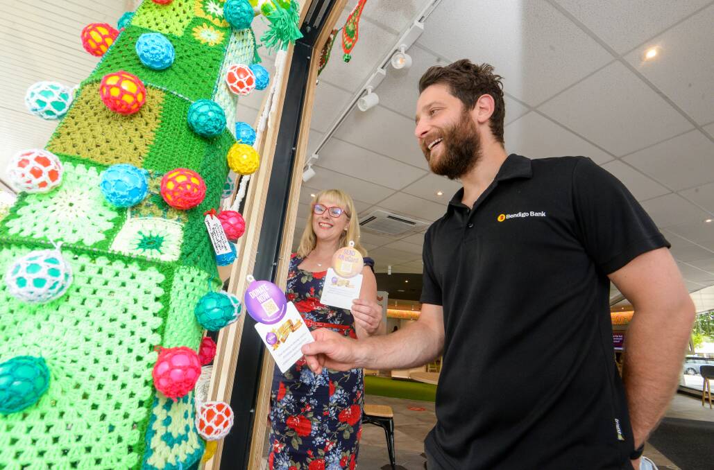 Rachel Mason and Dylan Villani with fundraising paper baubles for Bendigo Bank's crochet tree. Picture: DARREN HOWE
