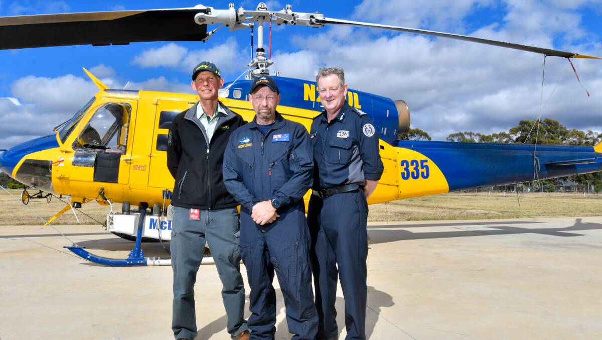 FFMVic's Carsten Nannestad, Pilot Todd McMahon and Regional Commander Bill Johnstone with the Helitak 335 water bomber. Picture: NONI HYETT