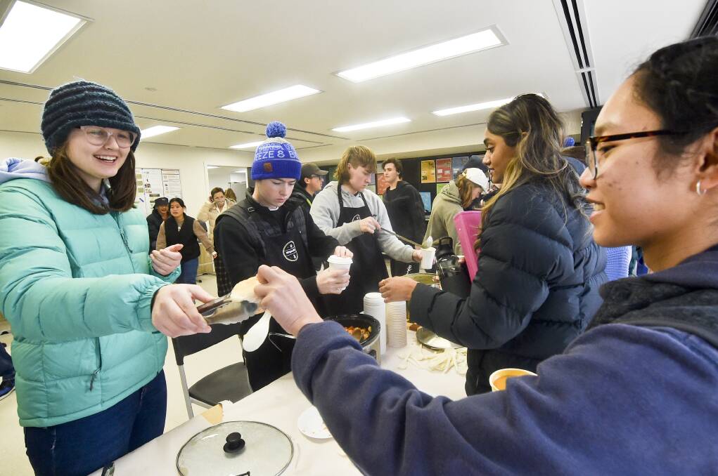 GIVING BACK: Lexi Woods distributes bread rolls to go with the soup. Picture: NONI HYETT
