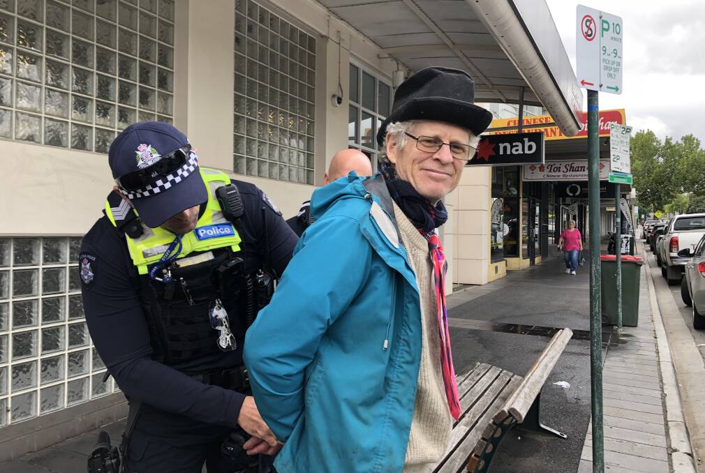 Central Vic Climate Action group member Bernard Tonkin, from Castlemaine, was briefly handcuffed and arrested in order to be removed from the NAB branch. Pictures by Jenny Denton