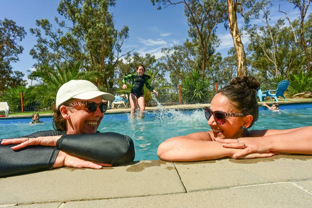 Shona Camilleri, who grew up in the area and sees blue-green algae as "par for the course" with friend Jess Hall in the pool at the Lake Eppalock Holiday Park. 
