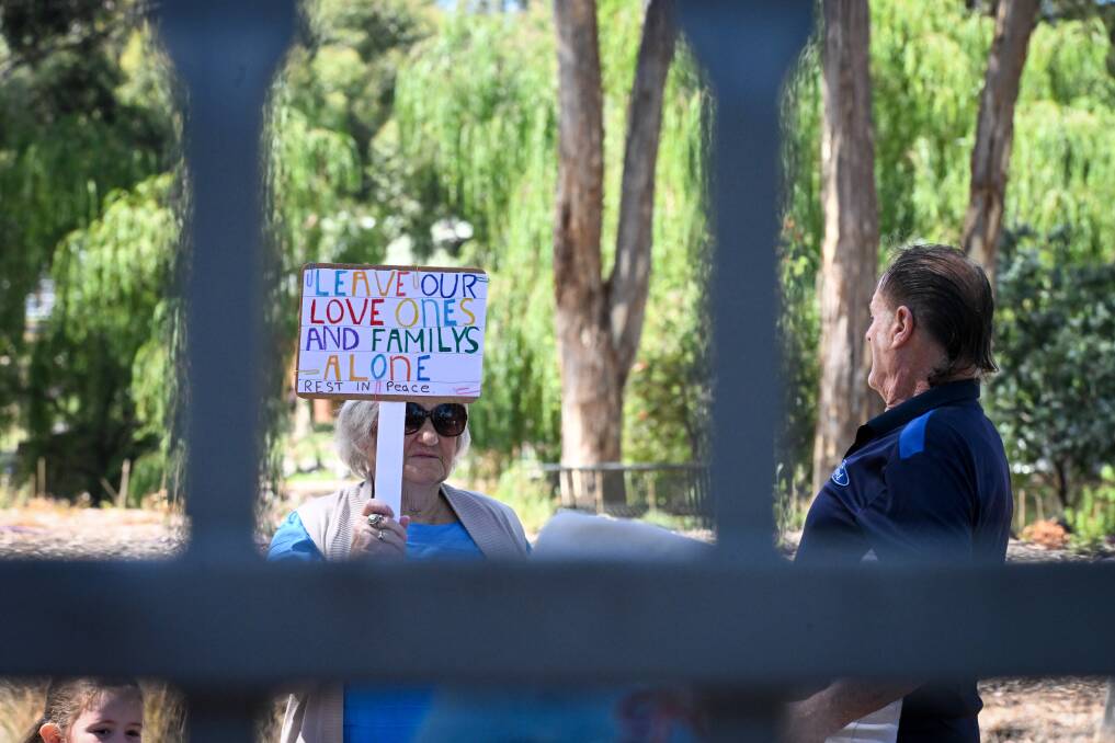 A woman holds a sign at a January 31 protest at Eaglehawk cemetery. Picture by Darren Howe