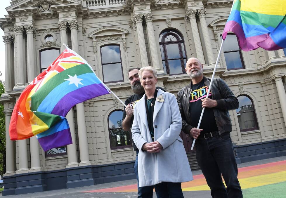 Pride festival organisers John Richards and Chris Butler with local MP Maree Edwards wave the flag for a $50,000 funding pledge.