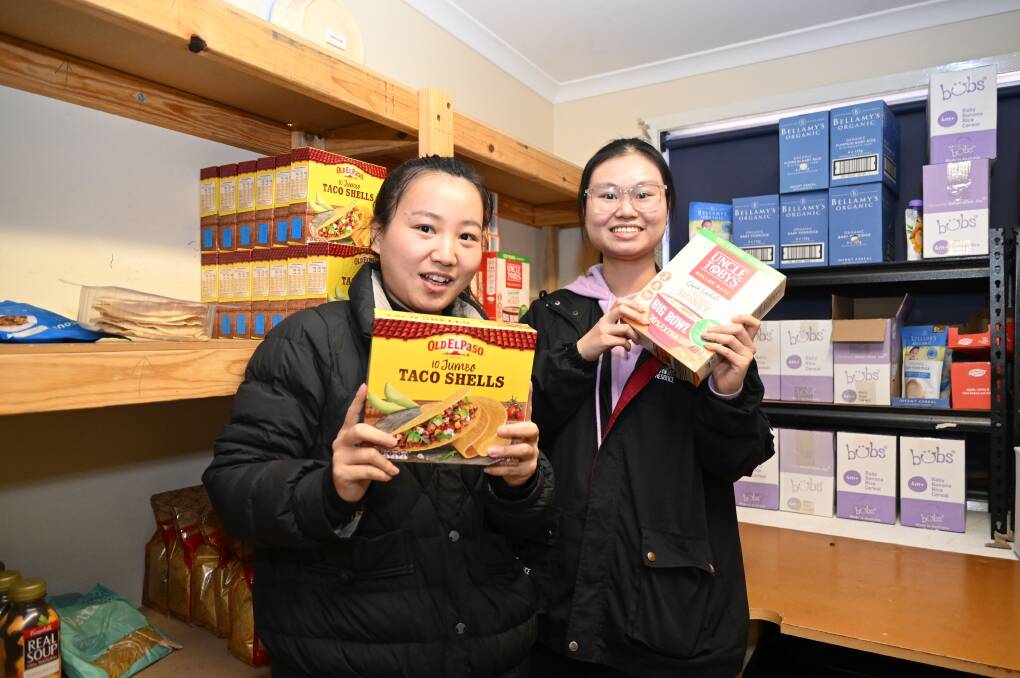 Volunteers Annie and Minh with some items from the food pantry. Picture by Enzo Tomasiello