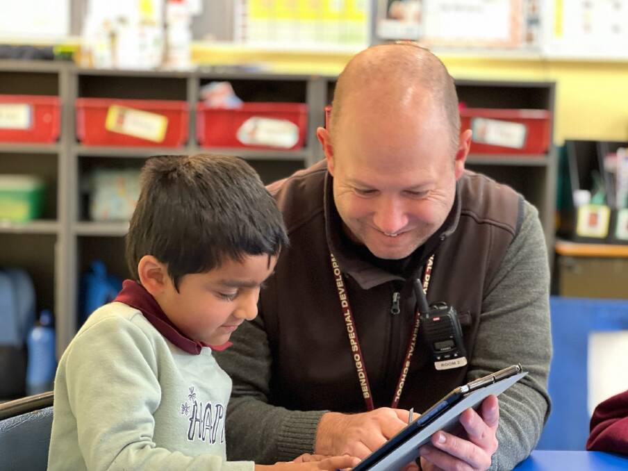 VIRTUAL VOICE: Bendigo Special Developmental School teacher Matt Higgins and student Abhay Jose test out the school's new iPads that will help non-verbal students to communicate in alternative ways. Picture: SUPPLIED