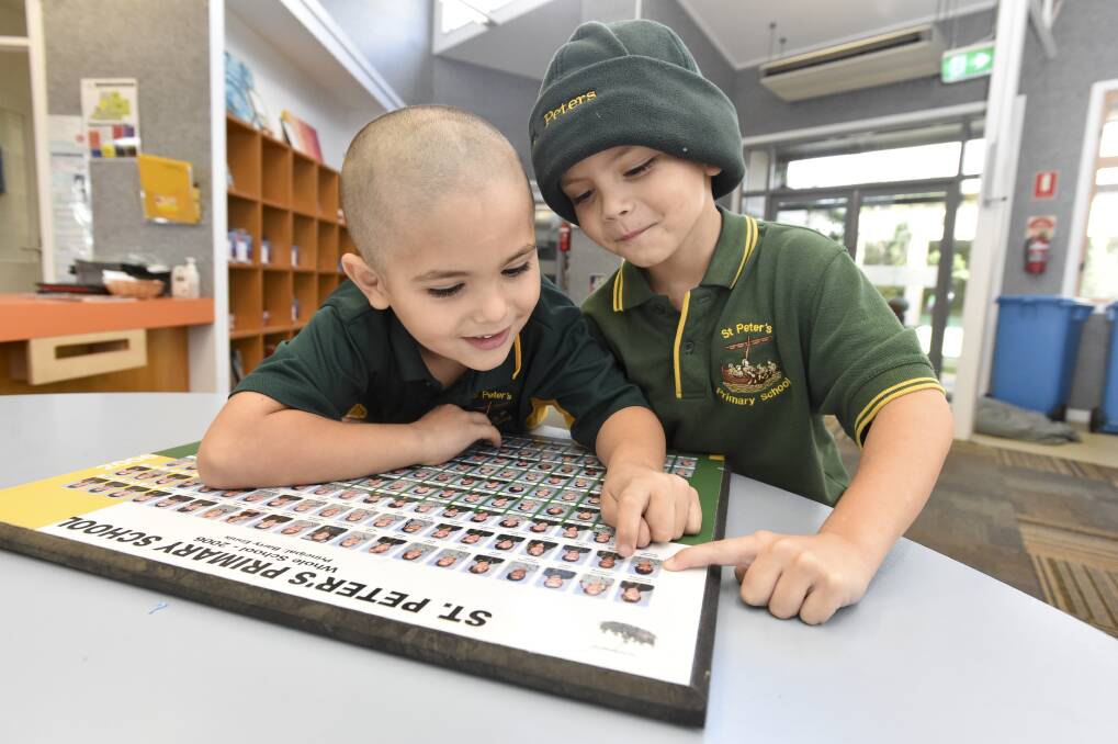 MEMORIES: St. Peter's Primary School students Andre and Nikiri Bysouth point out the school photo of their mum who also attended the school. Picture: NONI HYETT 