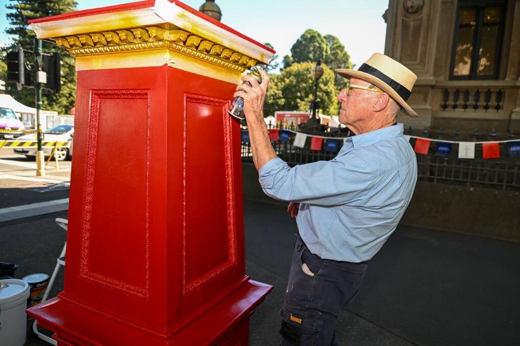 Mr Slocum cleans, sands and paints the post boxes. Picture by Enzo Tomasiello
