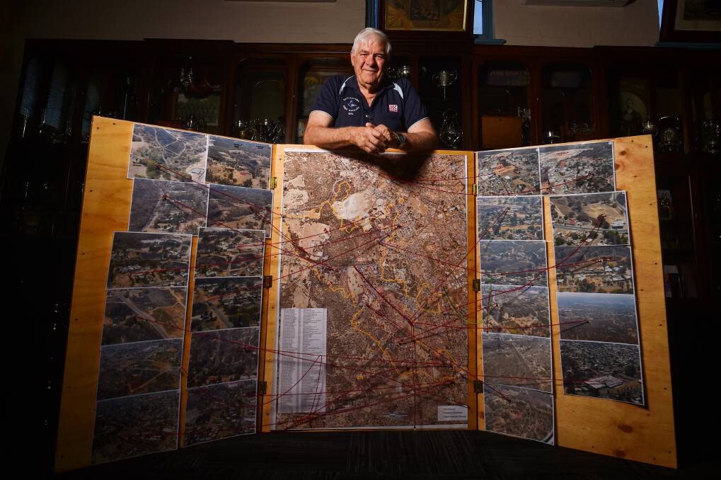 Eric Smith with a map of the fire boundary, and photos of the aftermath. Picture by Darren Howe