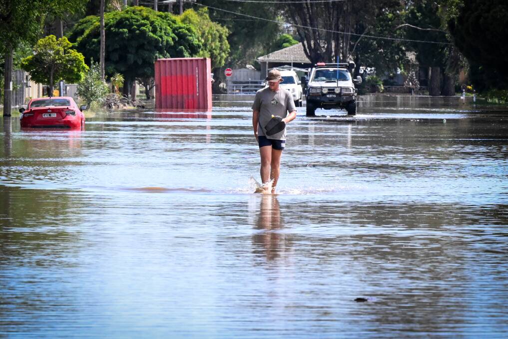 A man walks through a flooded street in Rochester. Picture by Darren Howe