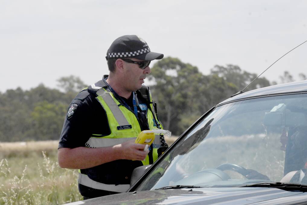 A police officer conducts a preliminary breath test. File picture