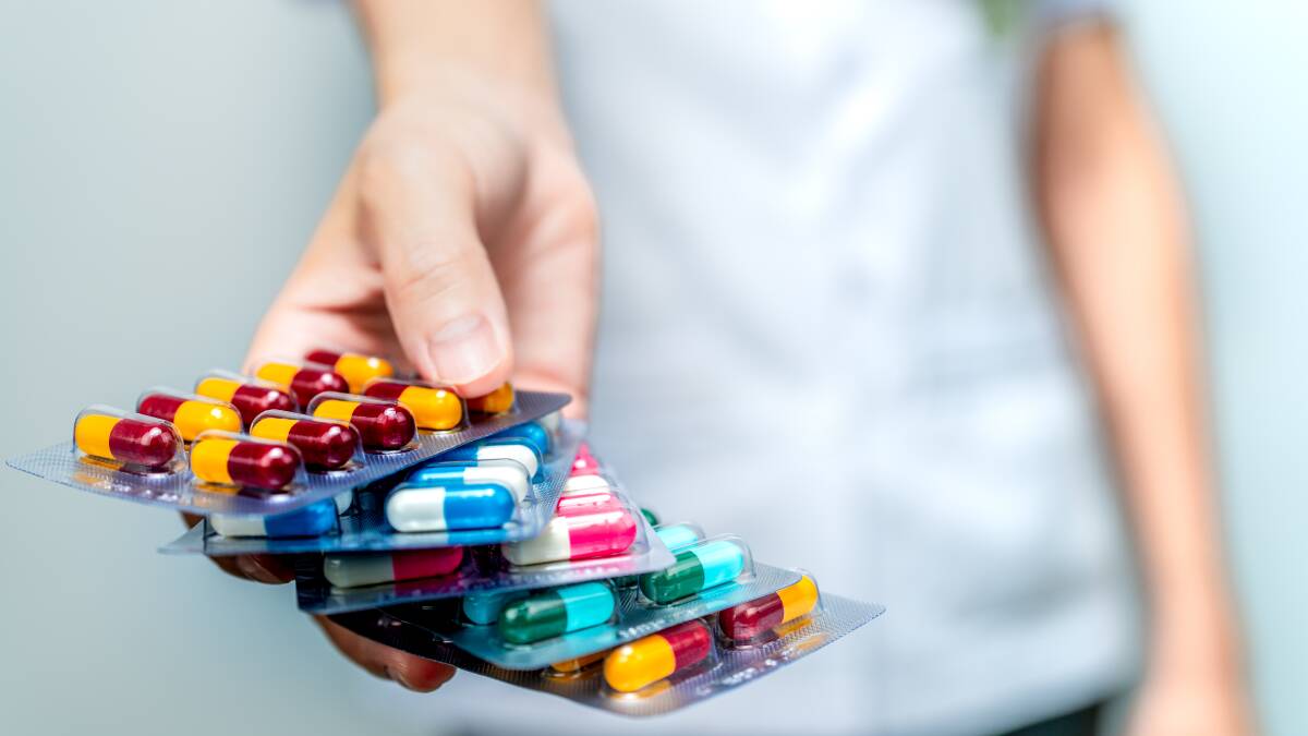 A person holding packets full of colourful pharmaceuticals. Picture: Shutterstock