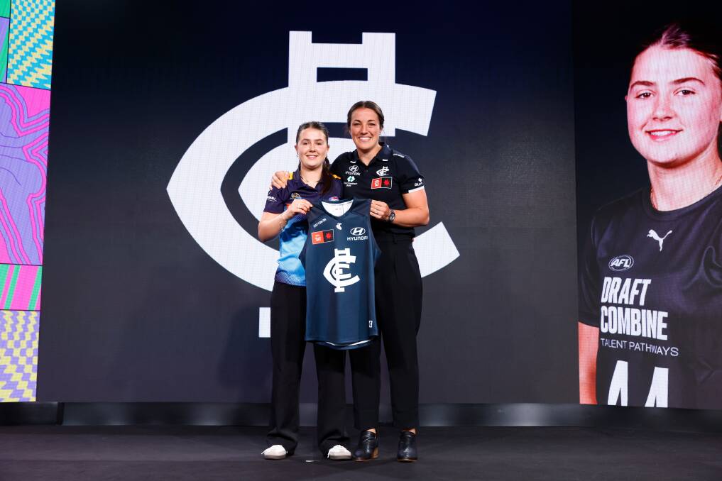 Lila Keck has her Carlton jumper presented by former Bendigo Pioneers Kerryn Peterson. Picture by Getty Images