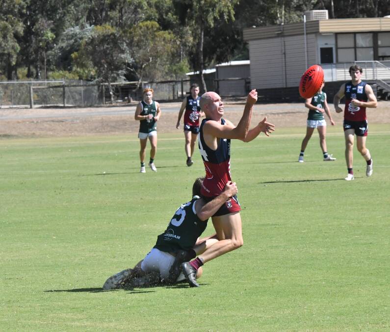 Sandhurt stalwart Alex Wharton gets a handball away just in time during the Dragons practice match against Echuca on Saturday. 