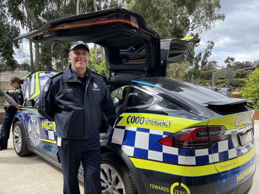 Victoria Police Inspector Ash Wigg with a Highway Patrol Tesla on show at the expo.