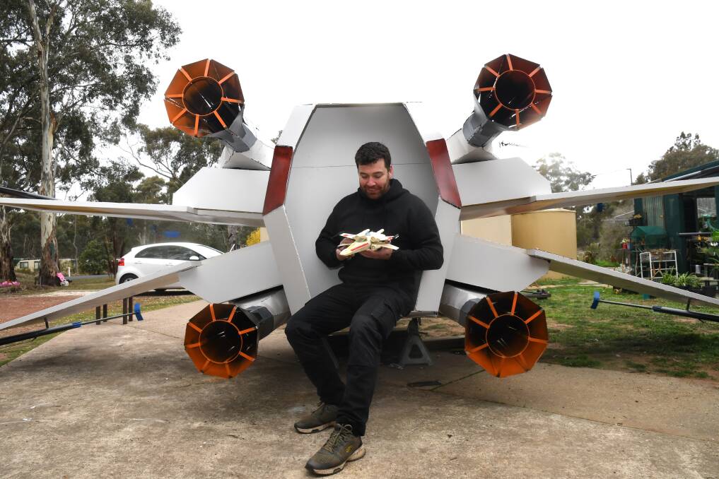 Eaglehawk Garden Sculptures' Stephen Brown with his more than eight metre Star Wars x-wing steel sculpture and the model it was based on. Picture by Noni Hyett