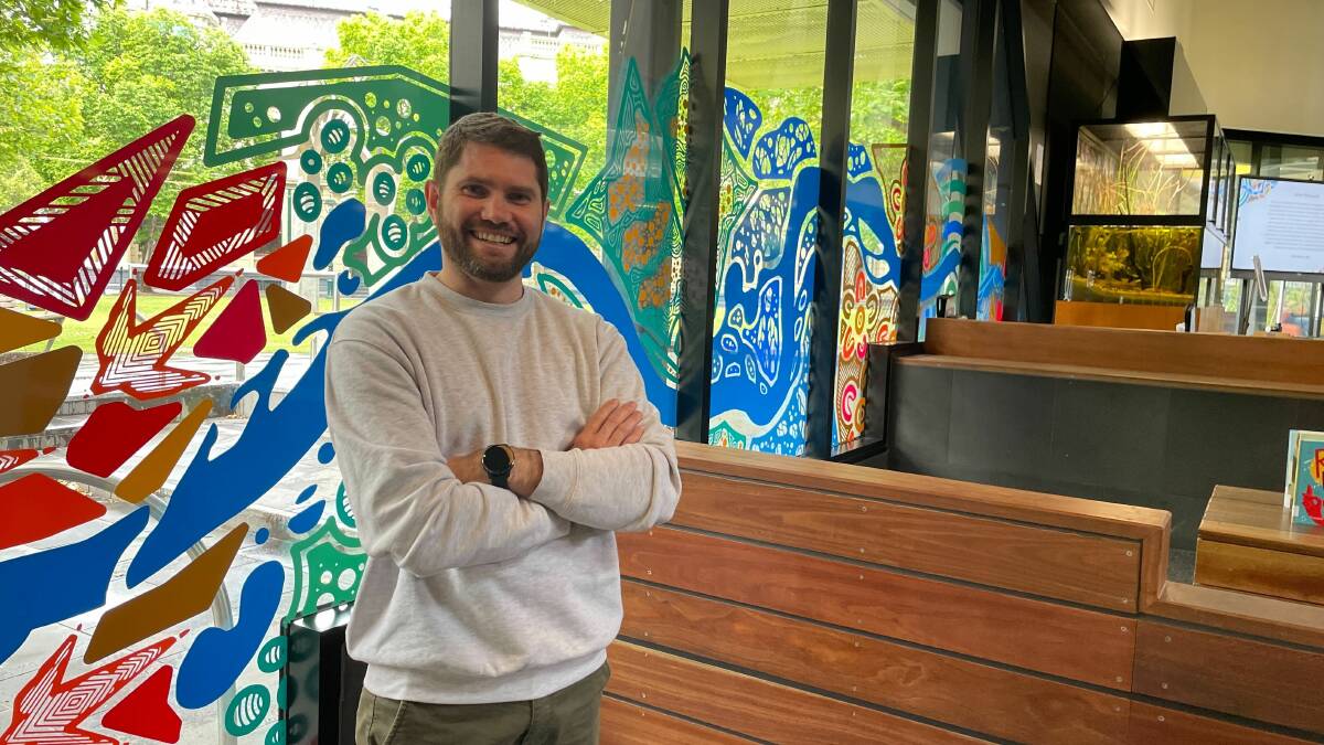 Troy Firebrace with his mural at Bendigo library. Picture by Jonathan Magrath 