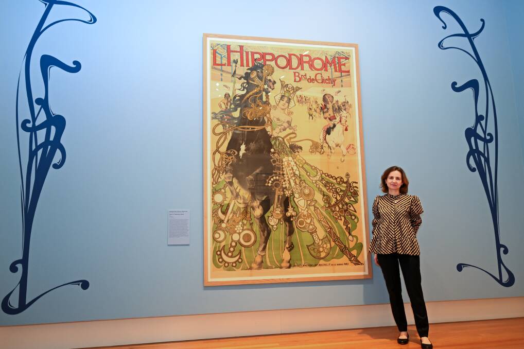 Anne-Laure Sol in front of one of the exhibition's posters. Photo by Enzo Tomasiello