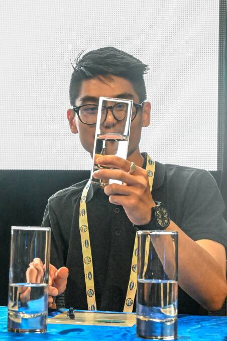 The colour of a water sample is examined by judge Zarif Yazid. Picture by Enzo Tomasiello