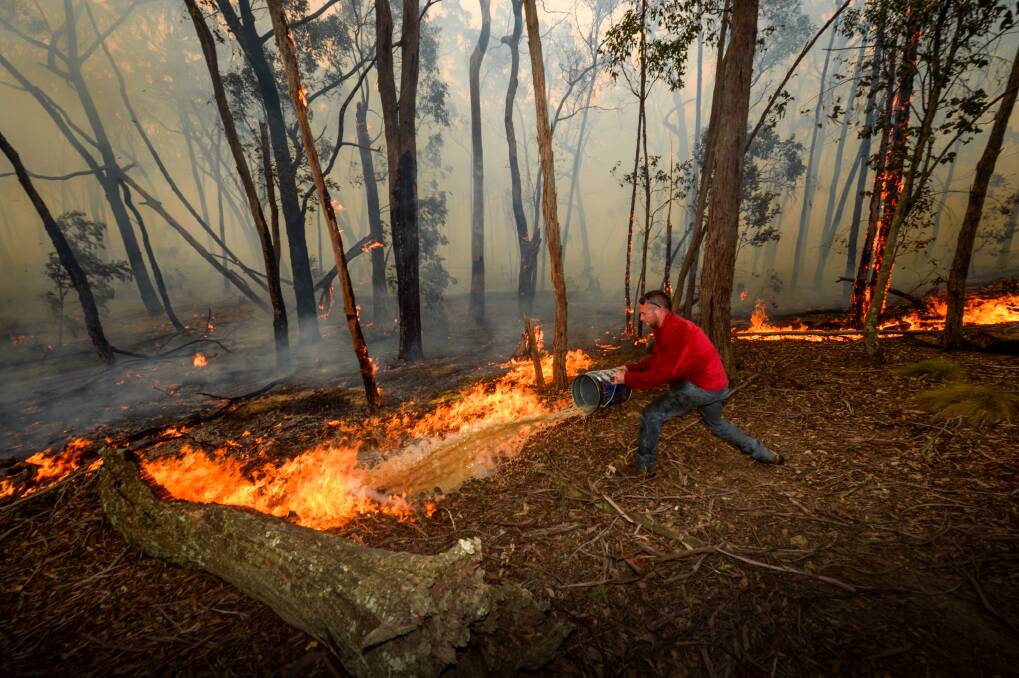 Ross Upfield douses flames during the October fires in Lancefield. Picture: JUSTIN McMANUS