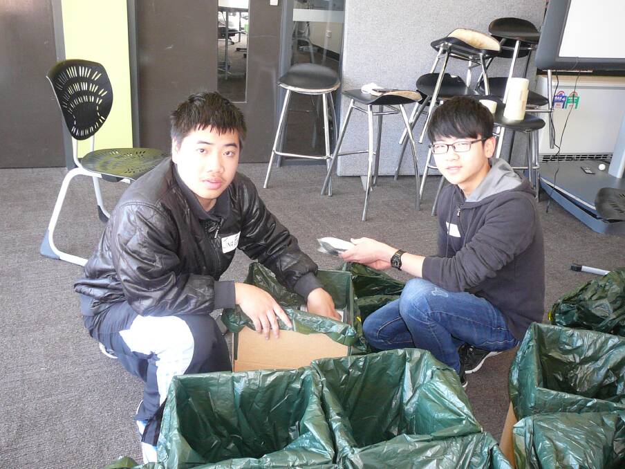 Bendigo Senior Secondary College international students Jingfeng Wu and Renjie Qin were among those lending a hand on Saturday. Picture: CONTRIBUTED
