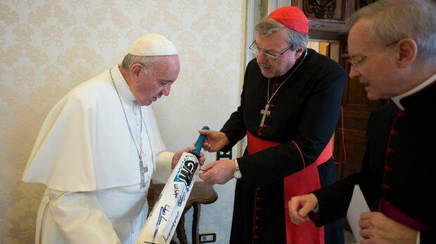 Pope Francis receives a cricket bat from Cardinal George Pell at the Vatican in 2015. Photo: L'Osservatore Romano/AP