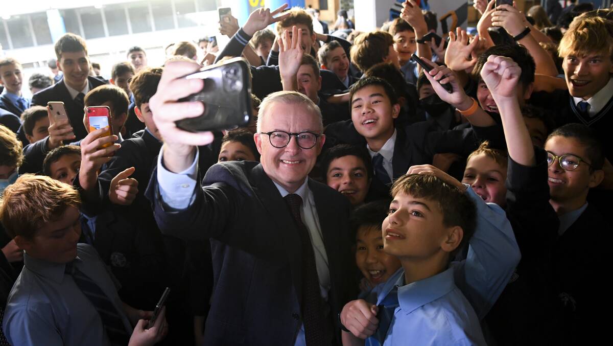Anthony Albanese poses for a selfie with students during a visit to his old school at St Mary's Cathedral school on day 29 of the 2022 federal election campaign, in Sydney. Picture: AAP