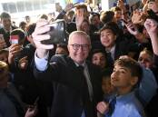 Anthony Albanese poses for a selfie with students during a visit to his old school at St Mary's Cathedral school on day 29 of the 2022 federal election campaign, in Sydney. Picture: AAP