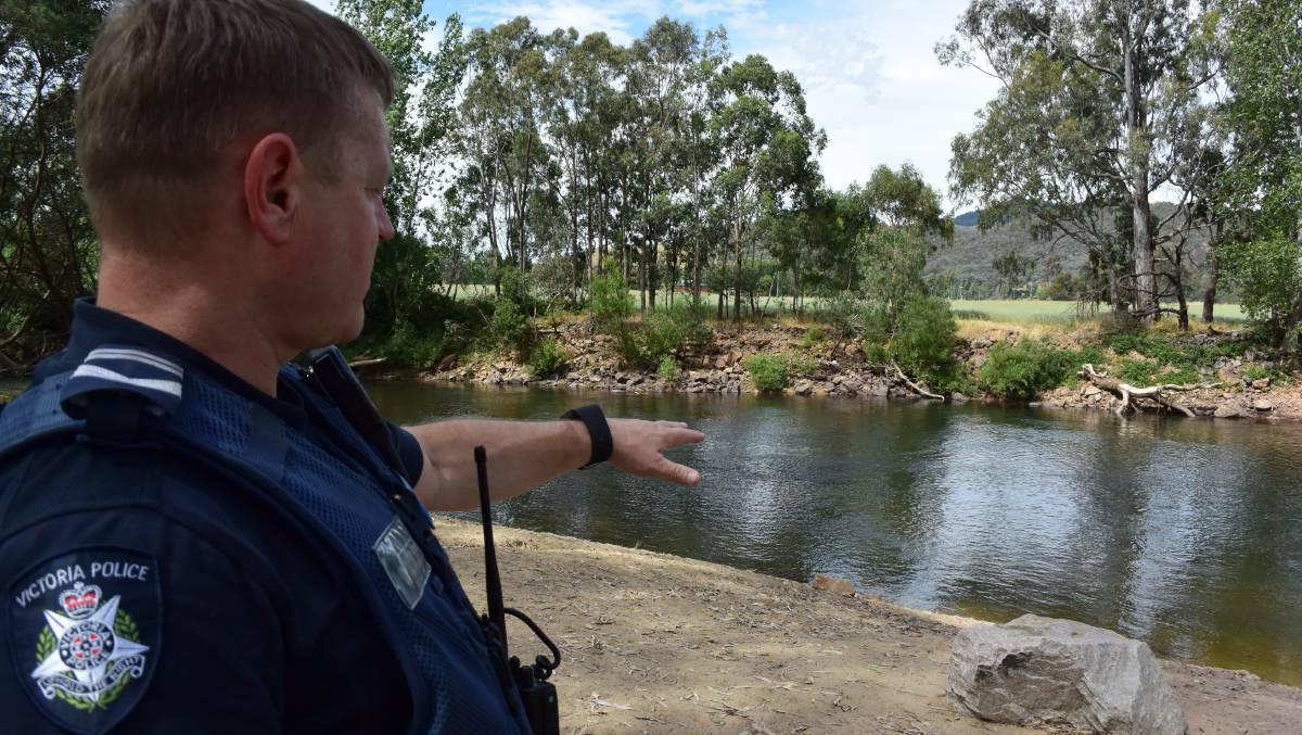 Tragic spot: Leading Senior-Constable Anthony Short points to the area in the Ovens River where a Malaysian man drowned on Tuesday while escaping the heat.