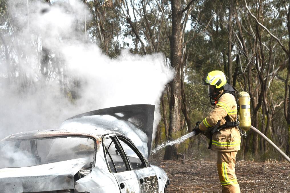 A firefighter extinguishes the blaze. Picture: DARREN HOWE