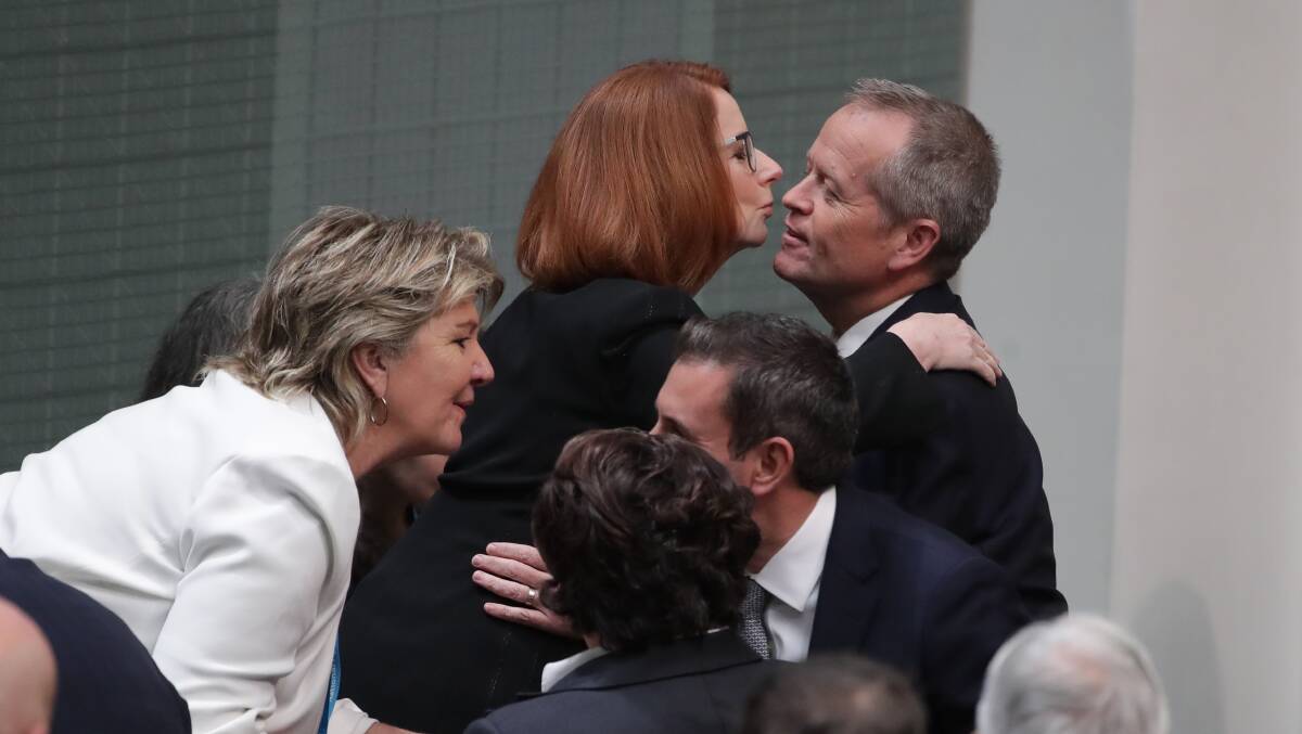 Former prime minister Julia Gillard embraces opposition leader Bill Shorten before the apology is delivered. Picture: Alex Ellinghausen
