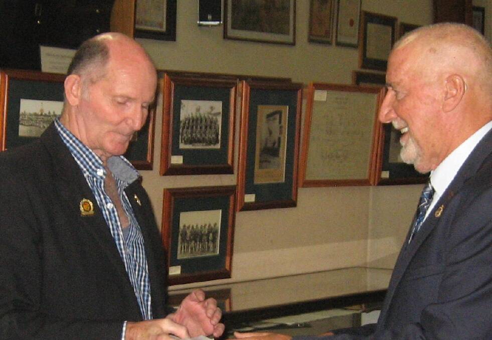 Local military historian Peter Ball (left) hands a cheque for $16,300 to Paul Penno of the Bendigo RSL, as part of a fundraising drive.