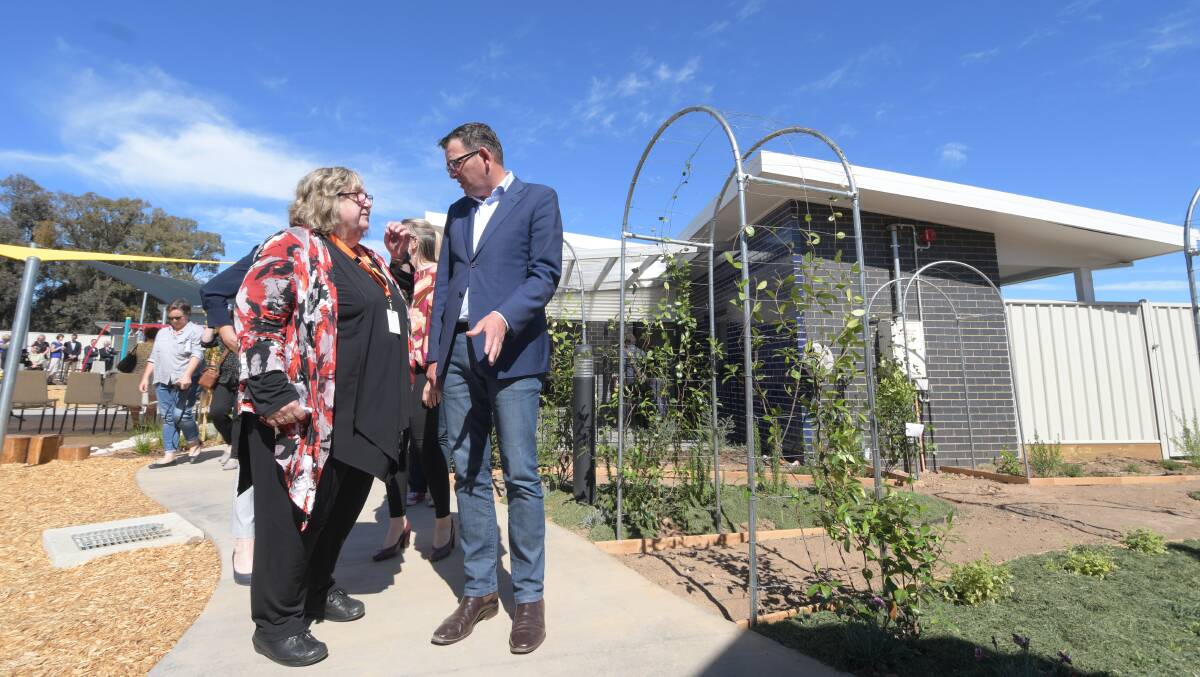 Julie Oberin discusses the Bendigo cluster women's refuge with Premier Daniel Andrews, alongside the centre's kitchen garden and one of the units. Pictures: NONI HYETT
