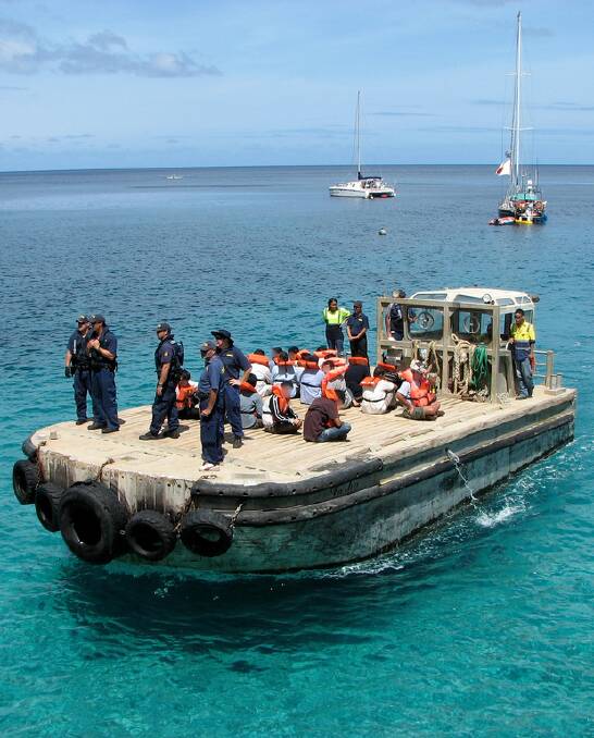 A boat carrying refugees arrives at Christmas Island under the watch of Australian Immigration officials. Image: Department of Immigration and Citizenship