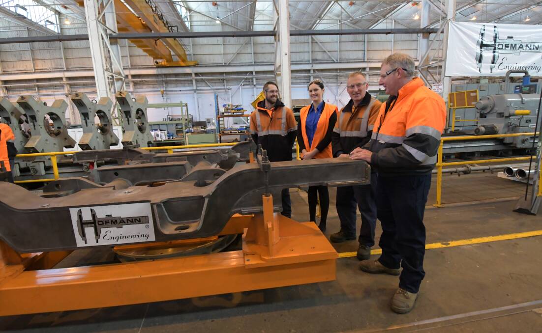 Hofmann Engineering staff with one of the bogie frames, which form the part of the base for new Metro trains. Picture: NONI HYETT