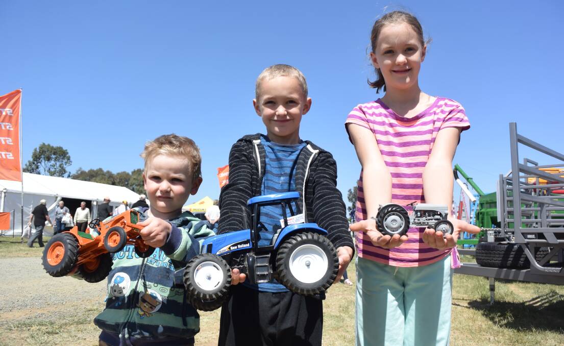 Luke Warren, of Maiden Gully, with Joshua and Brianna Sinclair, of Melbourne, pick out their favourite piece of miniature farm machinery.