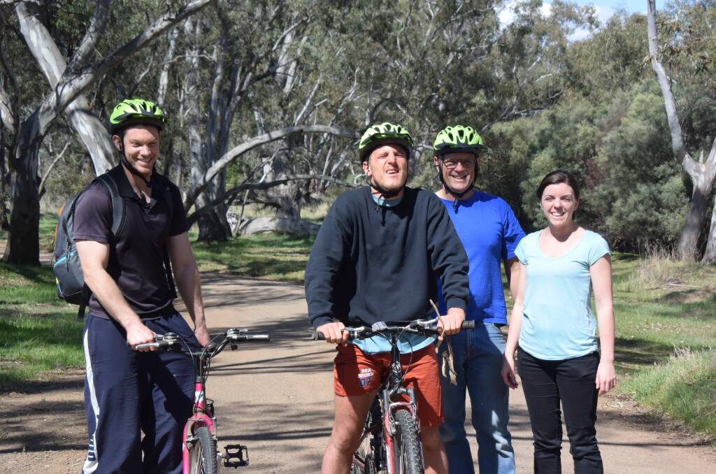 Support workers Glenn Day with Luke Modra, his father Mark Modra and support worker Laura Anderson on a bike ride around the property on Sunday. Picture: ADAM HOLMES
