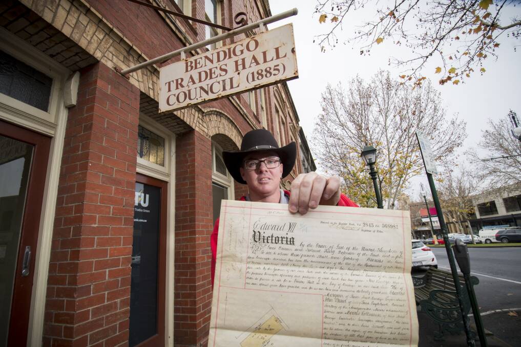 Bendigo Trades Hall Council secretary Luke Martin with the original restricted Crown Land grant from 1901, which handed over the hall. Picture: DARREN HOWE