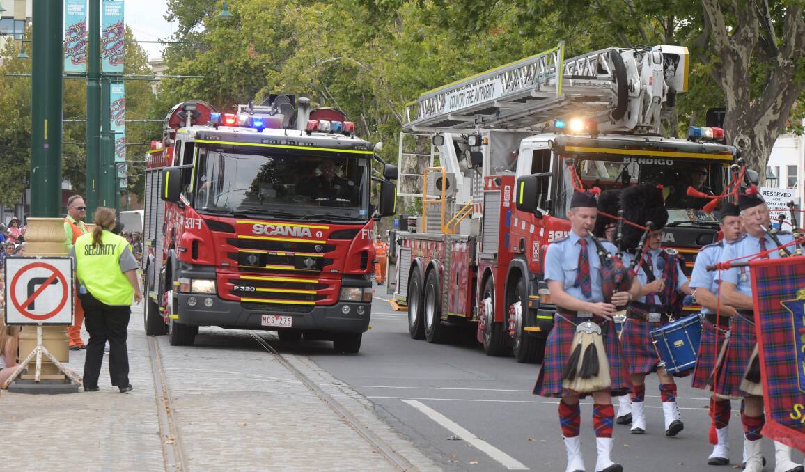 A fire truck attempts to exit the Easter Gala Parade on Sunday after being called to a structure fire in Long Gully. Picture: NONI HYETT