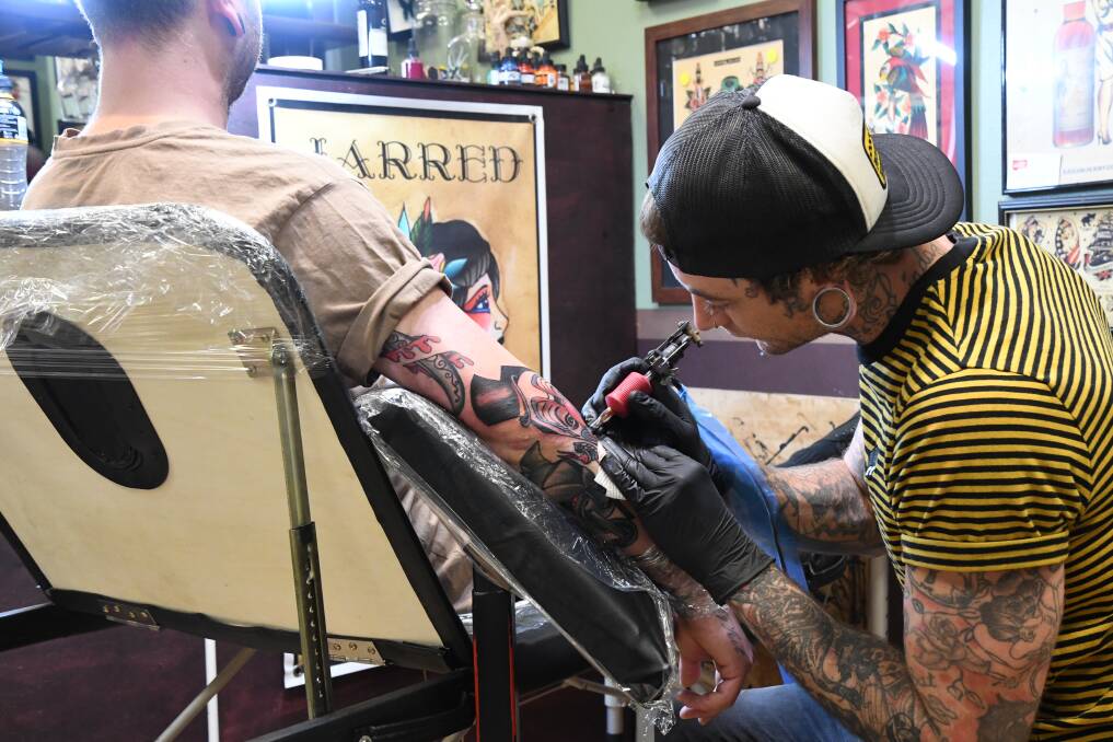 Jarred Boland finishes a tattoo. Picture: EMMA D'AGOSTINO