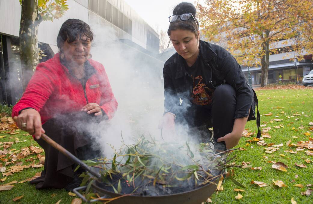 Auntie Marilyn Nicholls and Rhianna Kerr conduct a smoking ceremony in the Bendigo Library gardens to mark National Reconciliation Week. Picture: DARREN HOWE

