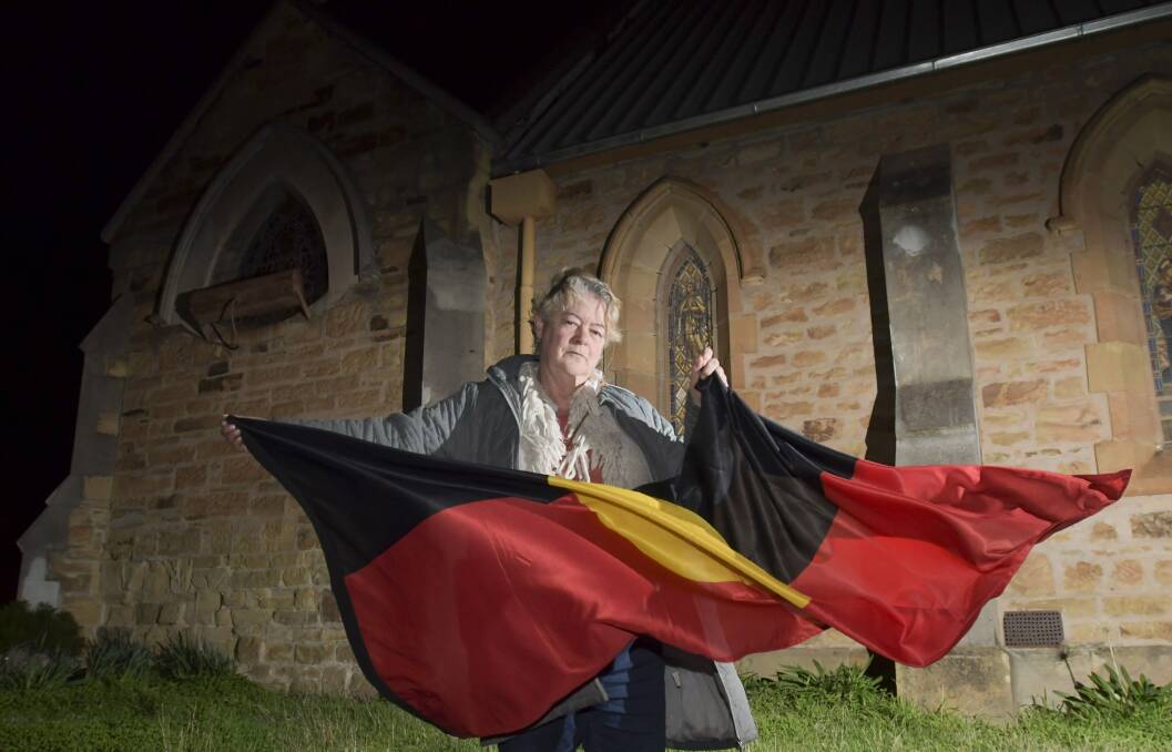 Janet Bromley with one of the art fair's two Aboriginal flags, back when one of the flags was missing. Picture: NONI HYETT