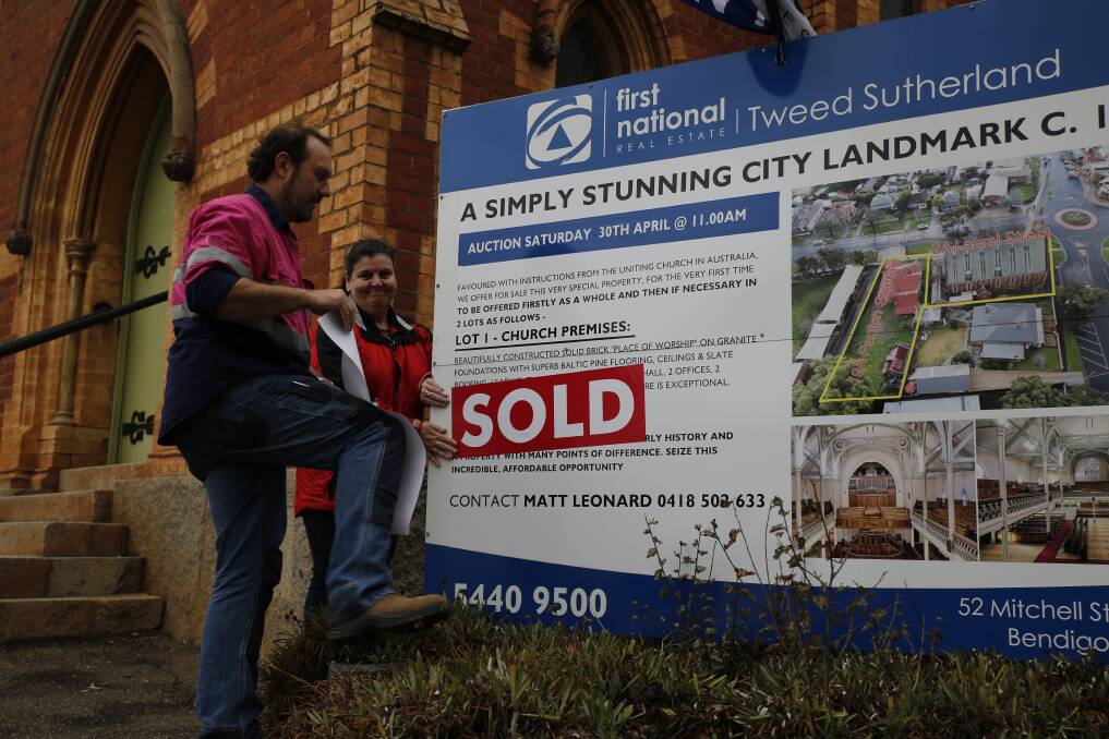 SOLD: Karen Jarmain and Gary Brusa of Melbourne put the sold sticker on the historic Golden Square Uniting Church. Picture: EMMA D'AGOSTINO