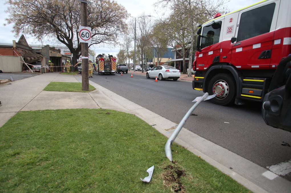 The ute crashed into a sign and a post before coming to a rest in the buildings. Picture: GLENN DANIELS